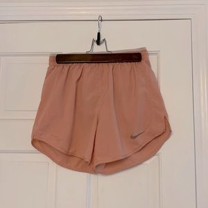 This is a pinkish coral colored pair of running shorts from Nike.